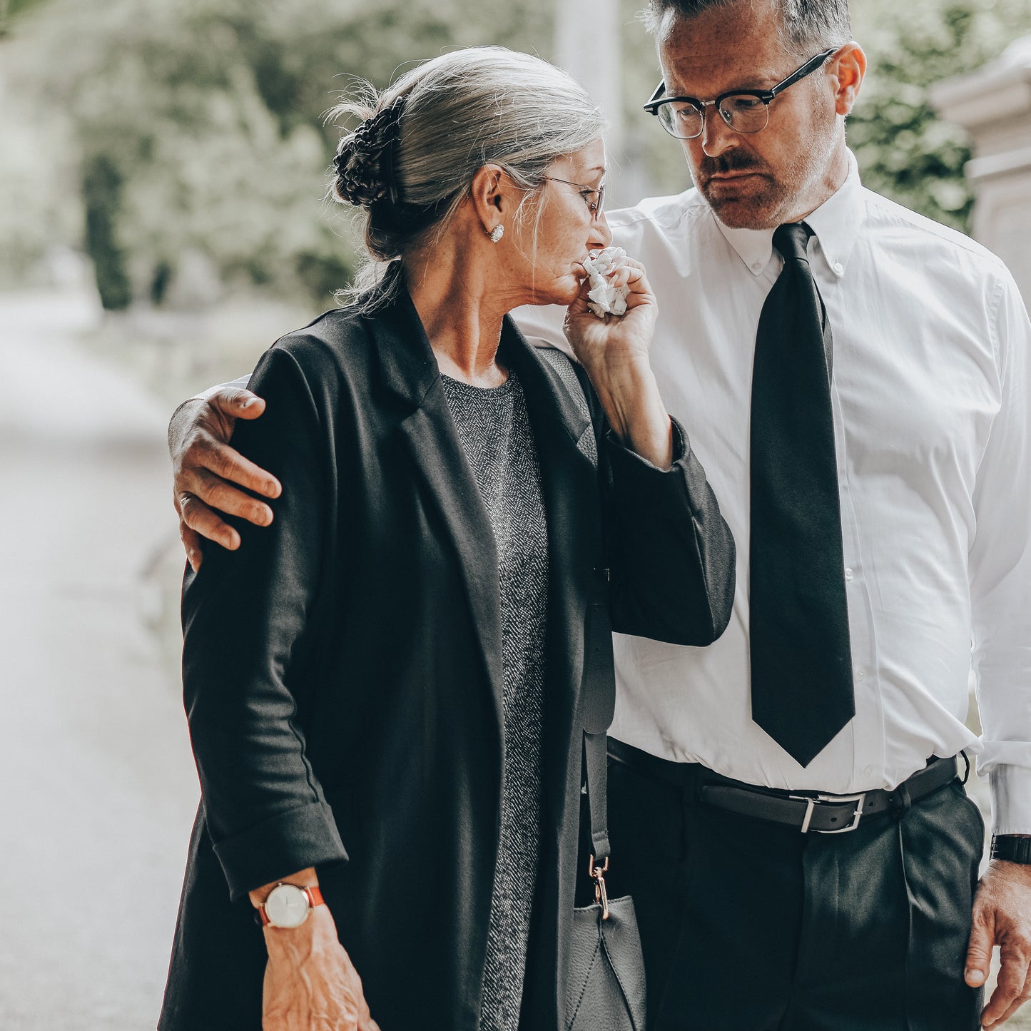 Have death certificate translated: A man comforts an elderly woman